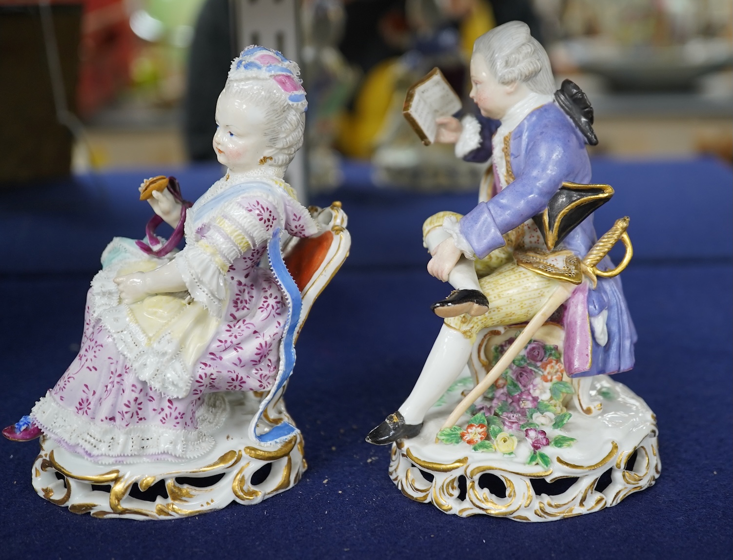 A pair of 19th century Meissen figures of a girl holding a shell and a boy holding a book, in size model number 628, tallest 13cm